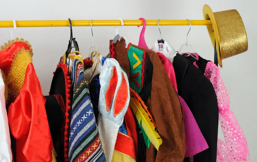 Colorful hanging costumes and accessories on a rack.