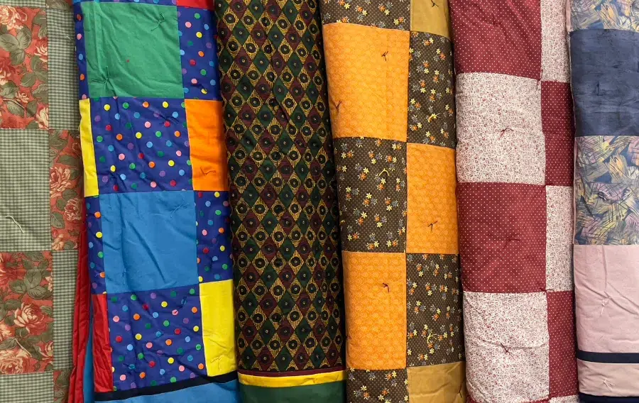 Colorful, patterned fabric rolls in a shop display.
