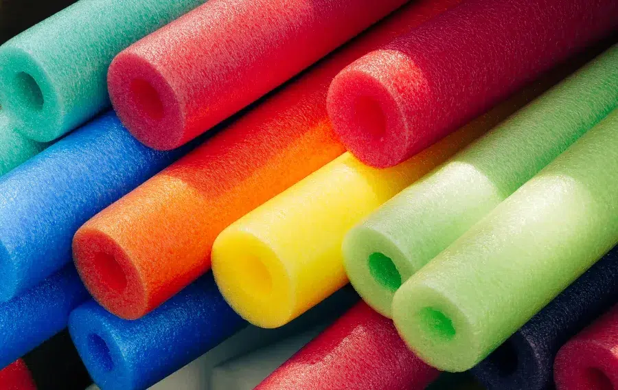 Colorful foam pool noodles stacked together.