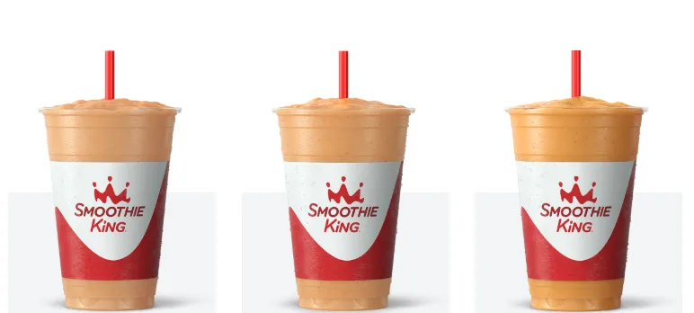 Three orange smoothies from Smoothie King in cups.