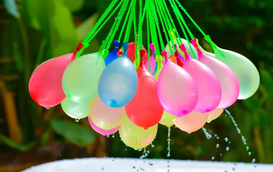 Colorful water balloons hanging outdoors.