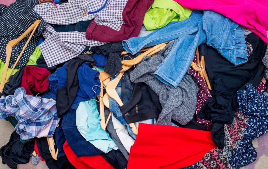Pile of colorful clothes with hangers