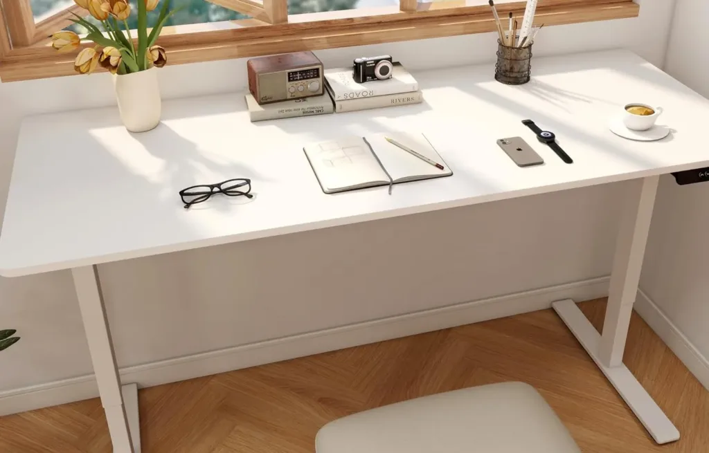 Minimalist desk by window, books, glasses, and coffee.