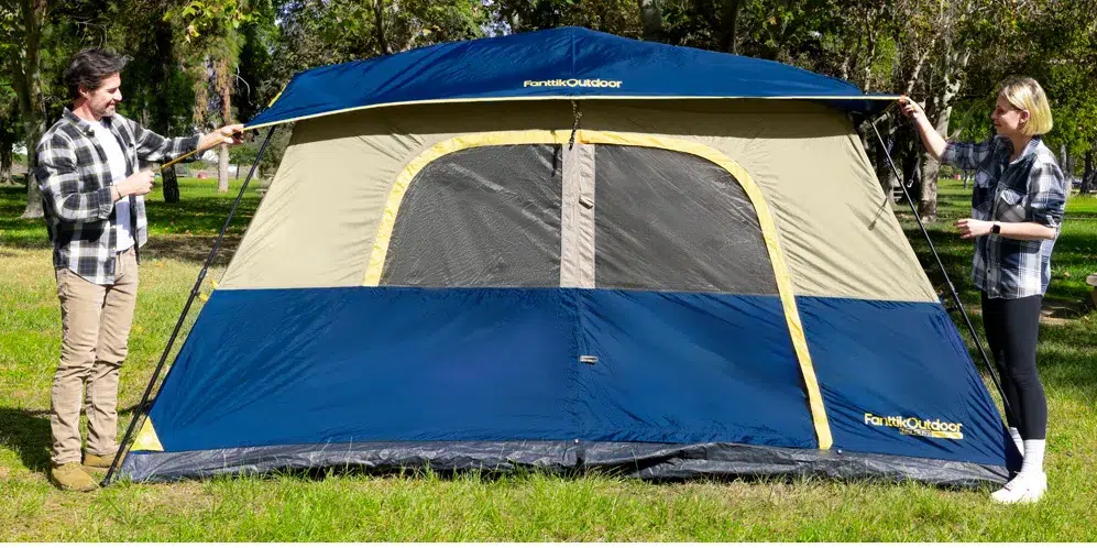Two people setting up a large outdoor tent.