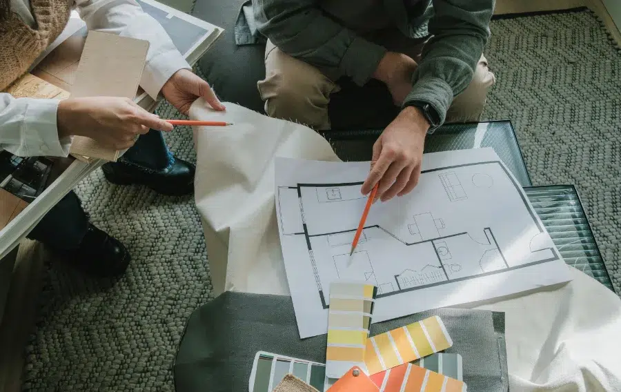 Designers discussing floor plan with color swatches.