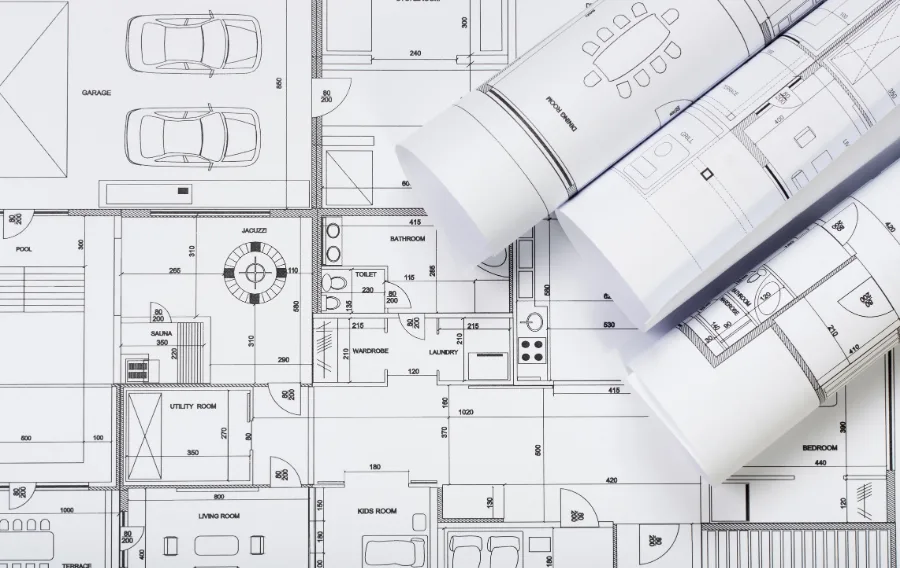 Architectural blueprints and floor plans on table.