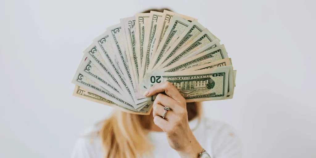 Person holding fanned U.S. dollars