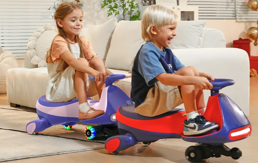 Children riding toy cars indoors, smiling.
