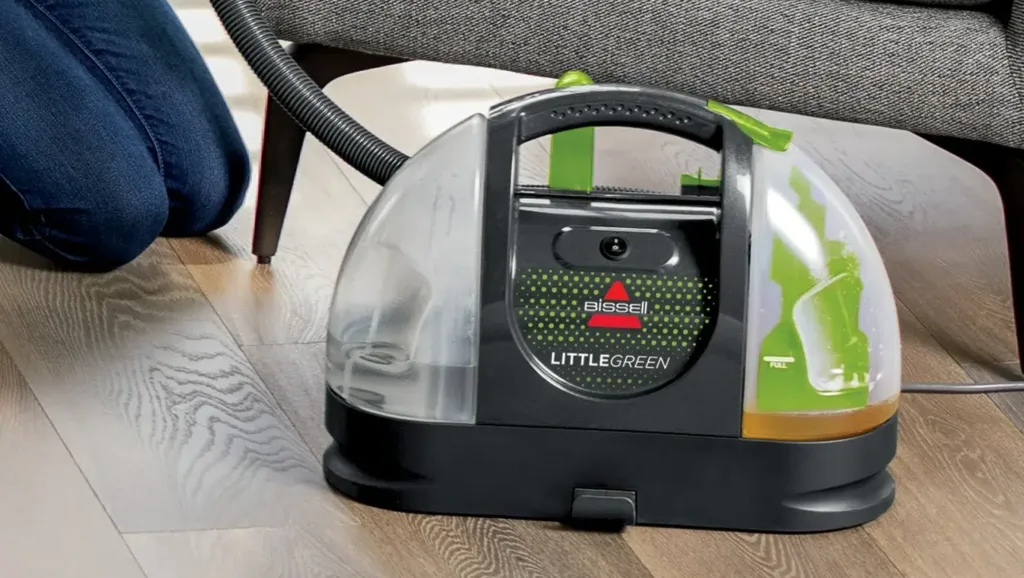 Cleaning couch pet stains with portable vacuum cleaner.