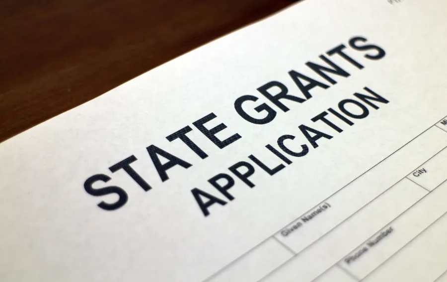 State grants application form on wooden table.