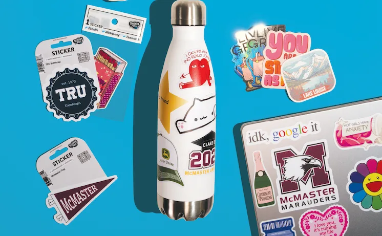 Decorated water bottle and laptop with assorted stickers.