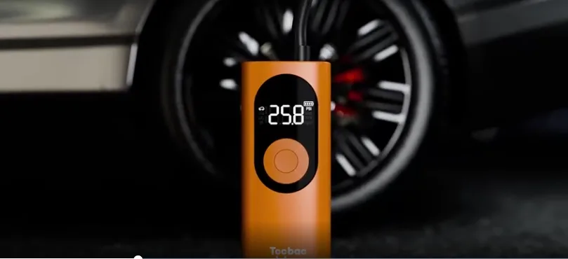 Orange digital tire inflator near car wheel.