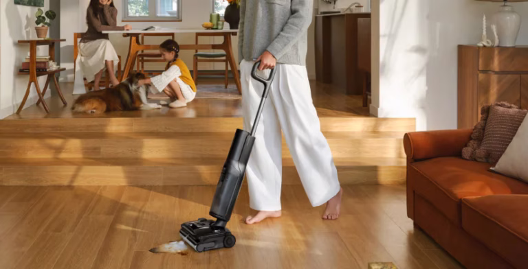 Person cleaning wooden floor with vacuum cleaner.